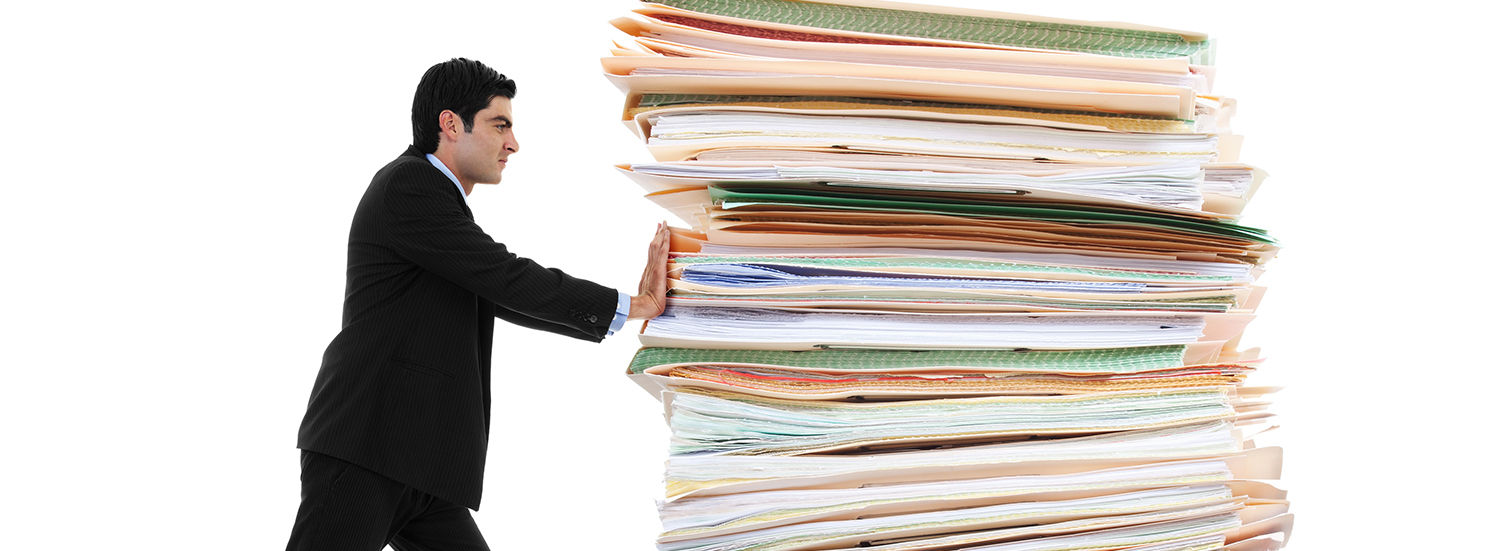 Stock image of businessman pushing a giant stack of documents isolated on white background Paper Pusher